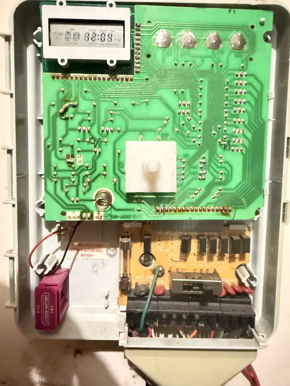 The opened controller: green logic board over an orange power board, with a soldered-in lithium battery